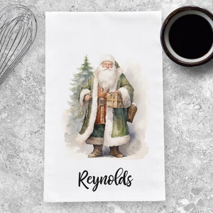 May include: A watercolor illustration of Santa Claus holding a gift, wearing a green coat with white fur trim, and standing next to a green Christmas tree. The text "Reynolds" is printed below the image.