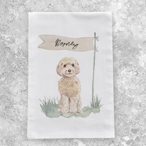 May include: A white tea towel with a watercolor illustration of a brown and white dog with the name "Barney" written on a banner above the dog.