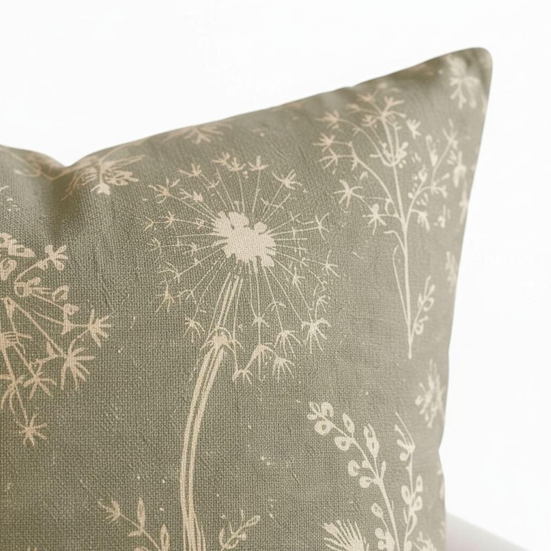 A close-up image of a decorative pillow with a floral pattern in shades of green and beige.