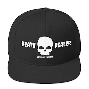 Pode incluir: Boné de beisebol preto ajustado com um gráfico de caveira preto e branco e o texto "DEATH DEALER" e "JOE LAZARICK DESIGNS" em branco.
