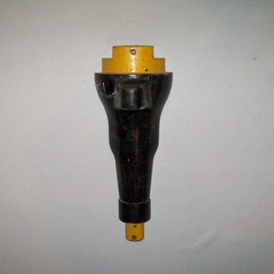 May include: A black and yellow metal tool with a handle and a pointed end. The tool has the text "REMARK" and "57767" printed on it.