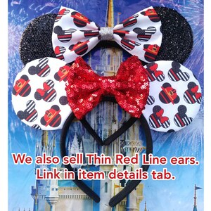 May include: A pair of black and white mouse ears with a red and white bow. The ears are decorated with a black and white pattern of fire hydrants and Mickey Mouse heads. The bow is made of red sequins. The ears are attached to a black headband. "We also sell Thin Red Line ears. Link in item details tab."