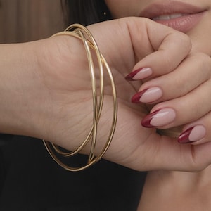 Conjunto de brazaletes triples entrelazados chapados en oro de 18 quilates