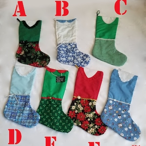 May include: Eight Christmas stockings with various patterns and colors, including green, blue, red, and white. The stockings are labeled with letters A through G.