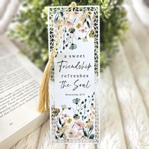 May include: White metal bookmark with a floral design and the quote "a sweet Friendship refreshes The Soul" with the scripture reference "Proverbs 27:9".