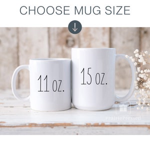 May include: Two white ceramic mugs with black text. The smaller mug is 11 oz and the larger mug is 15 oz.