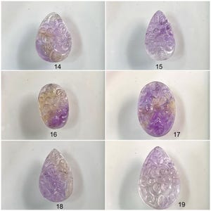 Puede incluir: Cinco colgantes de piedra preciosa de amatista con dise&ntilde;os florales tallados. Los colgantes son de varios tonos de morado y amarillo.