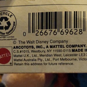 K&ouml;nnte beinhalten: Ein wei&szlig;er Karton mit einem Barcode, einem roten Mattel-Logo und dem Text "The Walt Disney Company ARCOTOYS, INC., A MATTEL COMPANY. C.S.#1015, Westbury, NY 11590-0115 MADE IN CHINA Mattel U.K., Ltd., Meridian West, Leicester LE3 2WT Mattel Australia Pty., Ltd., Port Melbourne, Victoria 3207 Retain this address for future reference."