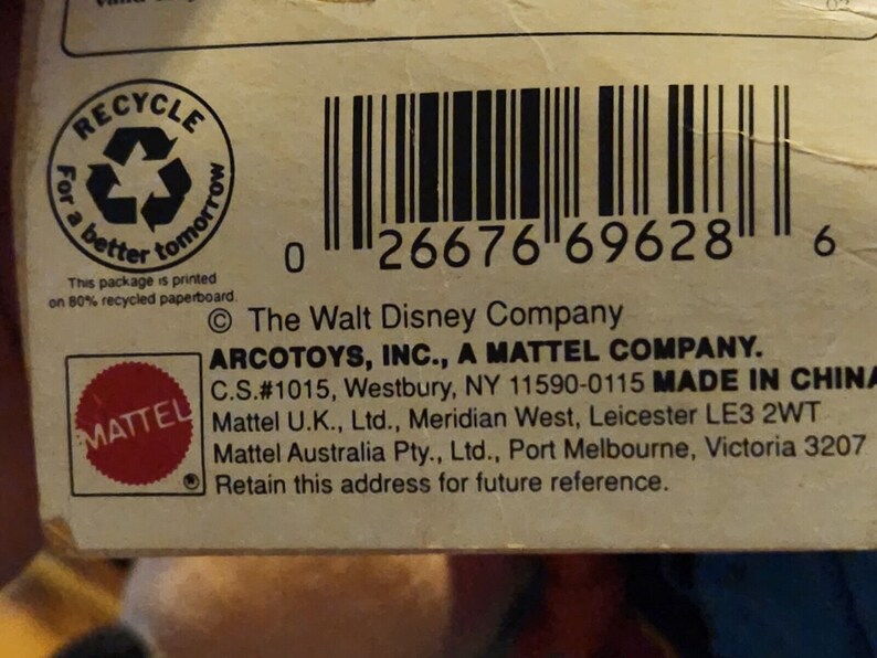 K&ouml;nnte beinhalten: Ein wei&szlig;er Karton mit einem Barcode, einem roten Mattel-Logo und dem Text "The Walt Disney Company ARCOTOYS, INC., A MATTEL COMPANY. C.S.#1015, Westbury, NY 11590-0115 MADE IN CHINA Mattel U.K., Ltd., Meridian West, Leicester LE3 2WT Mattel Australia Pty., Ltd., Port Melbourne, Victoria 3207 Retain this address for future reference."