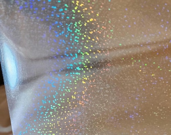 May include: A sheet of clear iridescent holographic vinyl with a rainbow pattern of small dots.