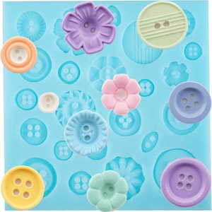 May include: A light blue silicone mold filled with various pastel-colored buttons and flower shapes. The buttons are in shades of yellow, orange, blue, and purple. The flowers are pink, purple, and green. The mold has a variety of button and flower designs.