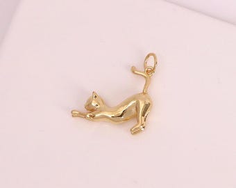 May include: A gold-colored cat charm in a stretching pose. The charm is made of a shiny, reflective metal and features a detailed design of a cat with its front paws extended and tail arched. The charm is likely for jewelry making.