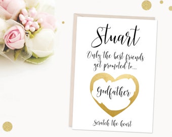 Può includere: Un biglietto bianco con lettere dorate che dice "Stuart Only the best friends get promoted to..." con un cuore dorato che dice "Godfather" e il testo "Scratch the heart" in basso.
