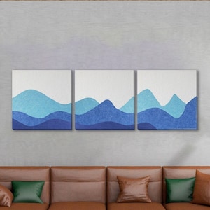 Pode incluir: Uma obra de arte em tela em tríptico com um design de paisagem de montanha. Cada painel exibe um gradiente de tons de azul, do claro ao escuro, criando um efeito em camadas. A obra de arte é montada em um fundo branco.