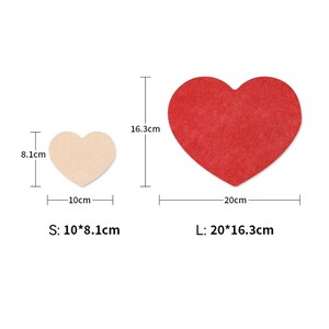 May include: Two felt heart shapes, one red and one beige, with measurements in centimeters. The red heart is 20 cm wide and 16.3 cm tall. The beige heart is 10 cm wide and 8.1 cm tall. The text "S: 10*8.1cm" and "L: 20*16.3cm" is below the hearts.