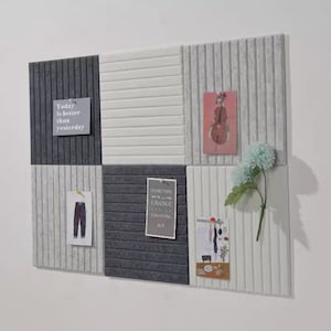 Puede incluir: Un panel acústico blanco y gris con una superficie texturizada. El panel está decorado con varios artículos, incluyendo una nota que dice "Hoy es mejor que ayer", una imagen de un violín, una imagen de jeans, una nota que dice "A veces el cambio es lo mejor", y una imagen de una bufanda.