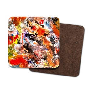 Puede incluir: Posavasos de arte abstracto con un diseño colorido que presenta salpicaduras de pintura roja, naranja, amarilla, azul y negra sobre un fondo blanco.