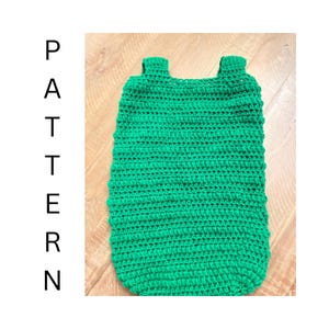 Puede incluir: Una prenda de ganchillo de color verde brillante con un diseño sin mangas, dos tirantes gruesos y un borde inferior redondeado. La palabra PATTERN está impresa verticalmente en letras mayúsculas negras a la izquierda.