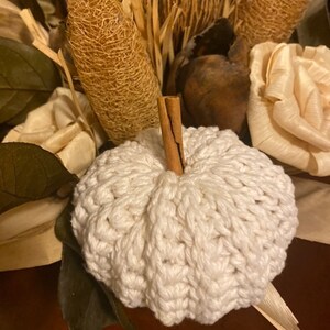 Handmade crochet pumpkins in different autumn colours arranged as seasonal fall home decor