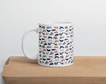 May include: White ceramic mug with a colorful pattern of sea slugs. The pattern features various colors, including blue, purple, pink, and green.
