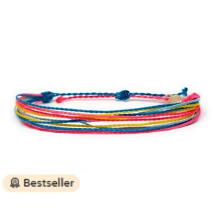 Può includere: Braccialetto in corda multicolore con chiusura dorata. Il braccialetto presenta sfumature di blu, giallo, rosa e grigio.