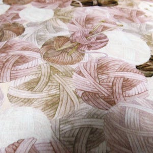 Peut inclure: Gros plan sur un tissu avec un motif répété de pelotes de laine dans des tons de marron, beige et blanc. Les pelotes de laine sont finement détaillées, suggérant un thème artisanal ou textile. La palette de couleurs globale est douce et sourde.