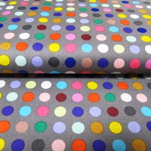 Può includere: Tessuto grigio con un motivo ripetitivo di pois colorati. I pois sono di varie tonalità di rosso, blu, verde, giallo, rosa e marrone.