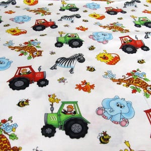 Op de afbeelding: Witte stof met een herhalend patroon van boerderijdieren, tractoren en bijen. De dieren omvatten olifanten, zebra's en leeuwen. De tractoren zijn rood en groen. De bijen zijn geel en zwart.