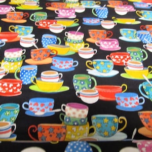 Könnte beinhalten: Ein Stoffmuster mit einem sich wiederholenden Design aus bunten Teetassen und Untertassen auf schwarzem Hintergrund. Die Teetassen sind in verschiedenen Farben gehalten, darunter Gelb, Blau, Rot und Rosa, mit Mustern wie Herzen, Sternen und Tupfen.