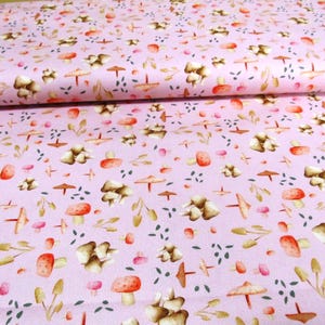 Könnte beinhalten: Rosafarbener Stoff mit einem sich wiederholenden Muster aus braunen Pilzen und Blättern. Die Pilze sind in verschiedenen Größen und Formen, und die Blätter sind in verschiedenen Grüntönen.