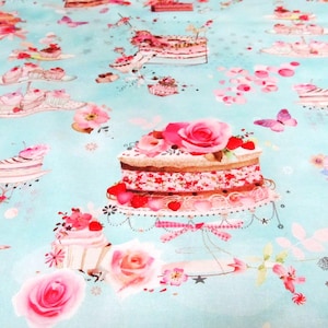 Puede incluir: Una tela turquesa con un patrón repetido de pasteles rosas y blancos, flores y mariposas. Los pasteles están decorados con glaseado rosa y chispas.