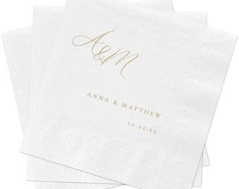 以下が含まれることがあります： 金色の筆記体で書かれた白い紙ナプキン。テキストは「A&M Anna & Matthew 10.22.23」と「Studio Lavender」です。