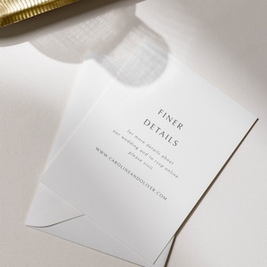 May include: White card with black text that reads "FINER DETAILS" and "for more details about our wedding and to rsvp online please visit WWW.CAROLINEANDOLIVER.COM".