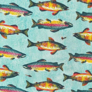 May include: A fabric pattern featuring a repeating print of rainbow trout fish on a light teal background. Each fish displays a yellow and orange underbelly, a dark spotted back, and a distinct pink lateral stripe, interspersed with small fishing flies.