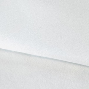 May include: A close-up shot of a white, textured fabric. The fabric is folded, creating a diagonal line across the image. The material appears soft and possibly felted, with a subtle, even texture.