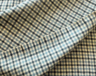 May include: A close-up of a blue and white checkered fabric. The fabric has a subtle gradient of blue shades, creating a visually interesting pattern.