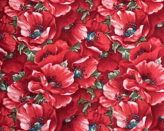 May include: A red fabric with a repeating pattern of red poppies. The poppies have white centers and green leaves.