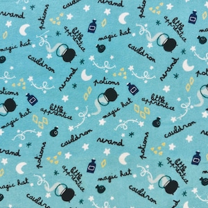 May include: Light blue fabric with a repeating pattern of black cauldrons, potion bottles, stars, moons, and the words "wand", "potions", "magic hat", and "little apprentice" in a whimsical font.