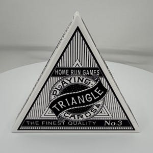 May include: A triangular deck of playing cards by Home Run Games, featuring a black and white geometric design. The front displays the text "HOME RUN GAMES", "PLAYING TRIANGLE CARDS", and "THE FINEST QUALITY No.3" in a bold, decorative font.