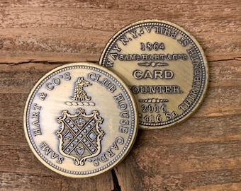 May include: Two antique brass tokens. The first token features a crest with playing card suits and the text "SAML HART & CO'S CLUB HOUSE CARDS". The second token features the text "WAY N.Y.S. PHILA. IS THE 1864 SAML HART & CO'S CARD COUNTER. 416 SO THIRTEENTH 2016".
