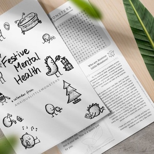 May include: A calendar titled "Festive Mental Health" with whimsical black and white illustrations. The calendar includes a word search and text from Anxious Little Monsters. The design is on white paper.
