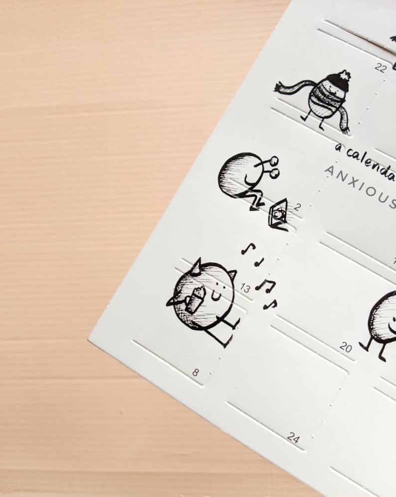 May include: A white calendar page with whimsical black ink illustrations. The drawings depict small, round characters in various poses, some with musical notes. The text "a calendar ANXIOUS" is visible. The calendar has numbered boxes for each day.