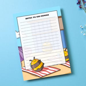 May include: A printable notepad with a bee theme. The notepad has a blue background with a beach scene and the text "Notes to Bee-member". There are two cartoon bees on the notepad.