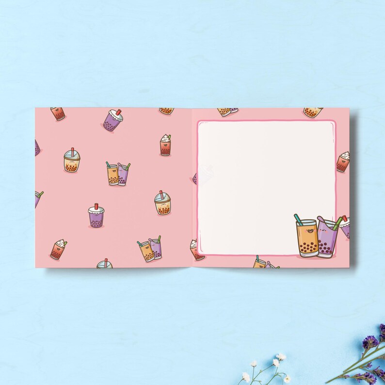 May include: A pink greeting card with a pattern of cartoon bubble tea drinks. The card is open, revealing a blank white space for a message. The bubble tea illustrations include various colors and toppings.
