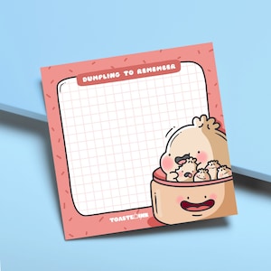 May include: A pink and white gridded notepad with the text "Dumpling to Remember" at the top. A cartoon illustration of a dumpling with a smiling face and smaller dumplings inside is at the bottom. The text "ToastInk" is at the bottom left corner.