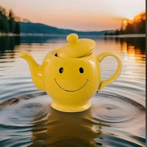 May include: A cheerful yellow teapot with a smiling face design. The teapot has a lid and a curved handle. The background features a lake and a sunset.