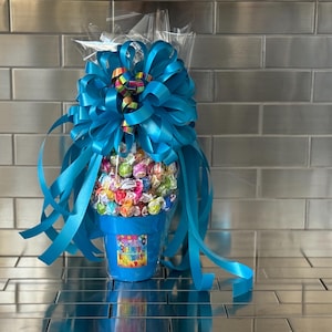 May include: A blue flower pot filled with colorful candy, topped with a large blue bow and a "Happy Birthday" label.