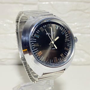May include: A vintage Poljot wristwatch with a silver-toned metal band and case. The watch face is black with silver hour markers and hands. The text "POLJOT" and "17 jewels" are visible on the face. The watch is marked "MADE IN USSR".