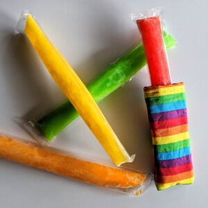 May include: Four frozen popsicles in plastic wrappers, one yellow, one green, one orange, and one red. The red popsicle is in a rainbow striped fabric pouch.