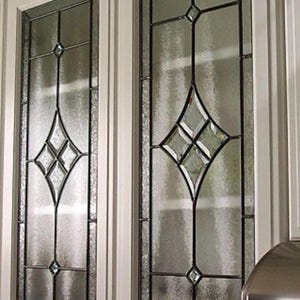 May include: Two off-white kitchen cabinet doors featuring rectangular glass panels with leaded caming. The glass has a textured, frosted appearance and includes a central diamond-shaped decorative motif with small clear glass accents.